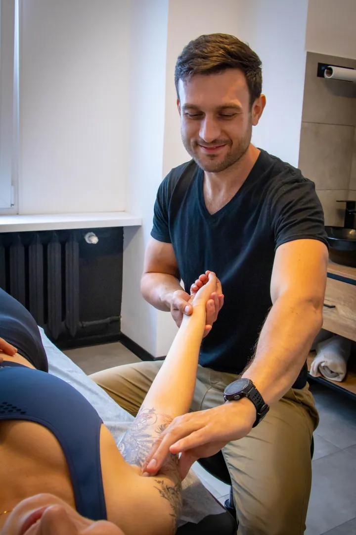 Fizjoterapeuta Smart Physio Będzin wykonuje terapię powięziową Fascial Manipulation na przedramieniu pacjenta z bólem łokcia